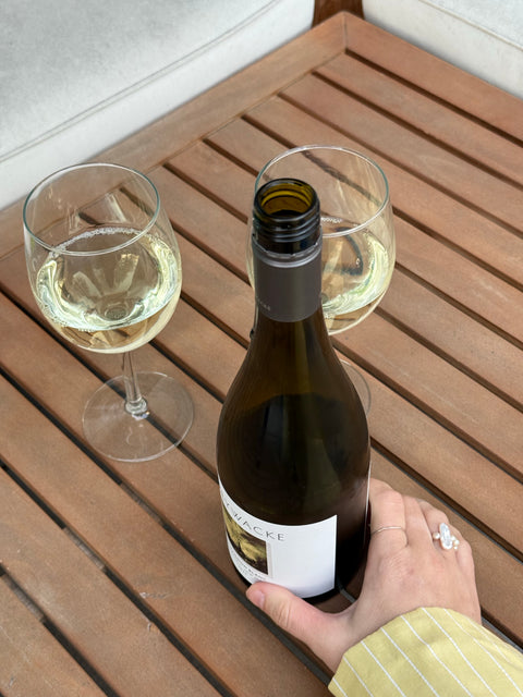 Bottle of white wine and two glasses on a wooden table
